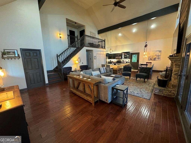 living room with a stone fireplace, high vaulted ceiling, dark hardwood / wood-style floors, and ceiling fan