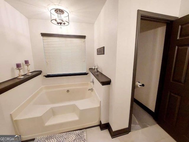 bathroom with a tub, tile patterned floors, and an inviting chandelier