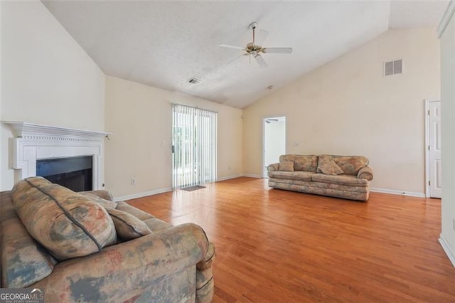 living room with ceiling fan, light hardwood / wood-style flooring, and high vaulted ceiling