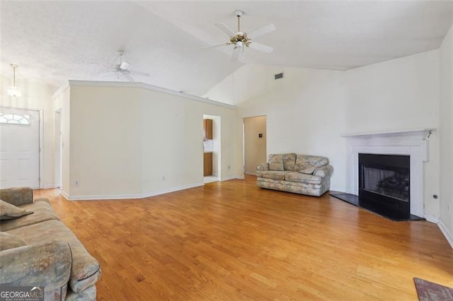 living room featuring ceiling fan, wood-type flooring, and vaulted ceiling