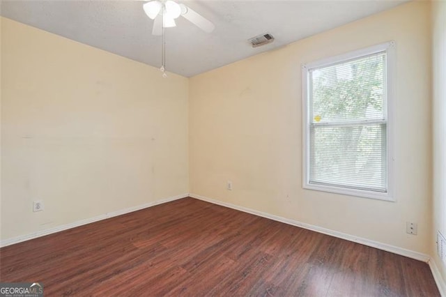 spare room featuring dark wood-type flooring and ceiling fan