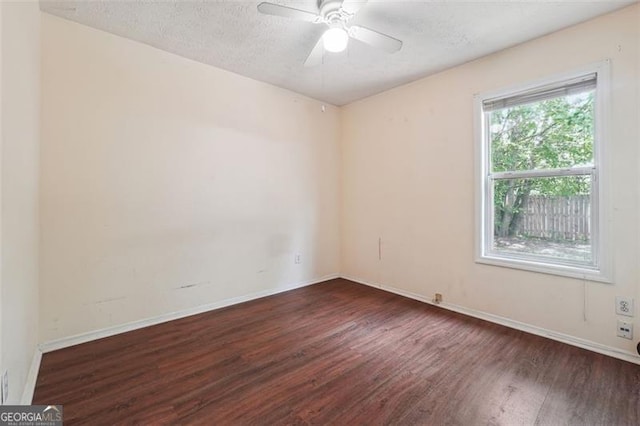 empty room with dark wood-type flooring, ceiling fan, and a textured ceiling