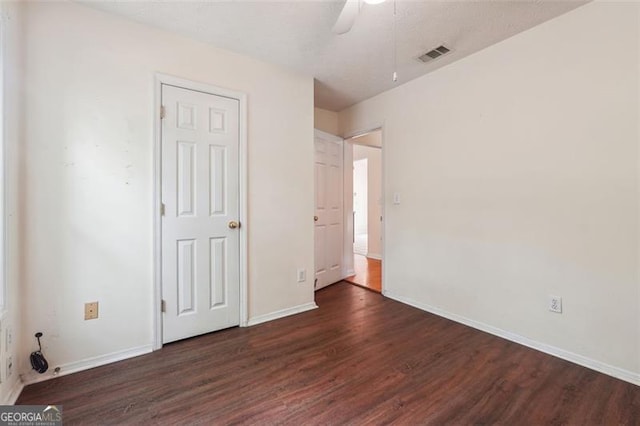 unfurnished bedroom with ceiling fan and dark hardwood / wood-style floors