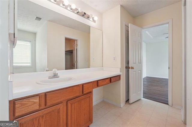 bathroom with hardwood / wood-style flooring, vanity, and a textured ceiling