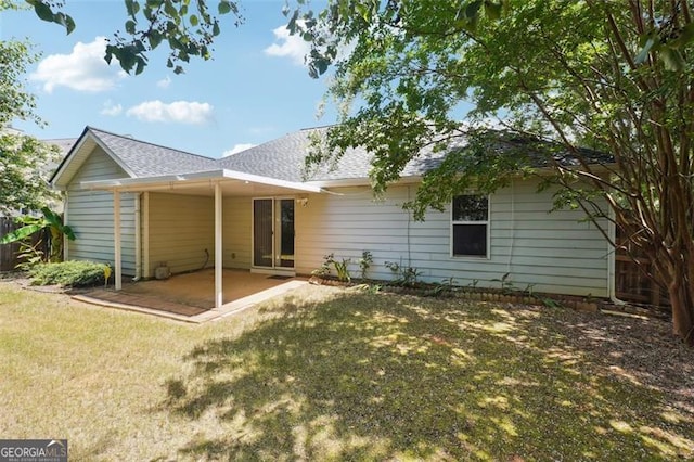 back of property with a lawn and a patio