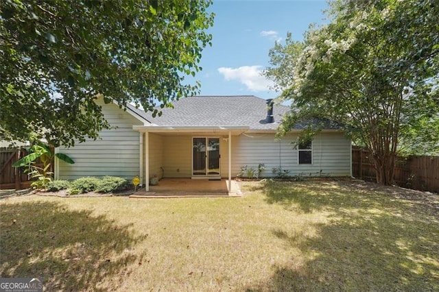 rear view of house with a lawn and a patio