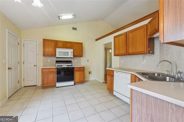 kitchen featuring vaulted ceiling, decorative backsplash, sink, light tile patterned floors, and white appliances