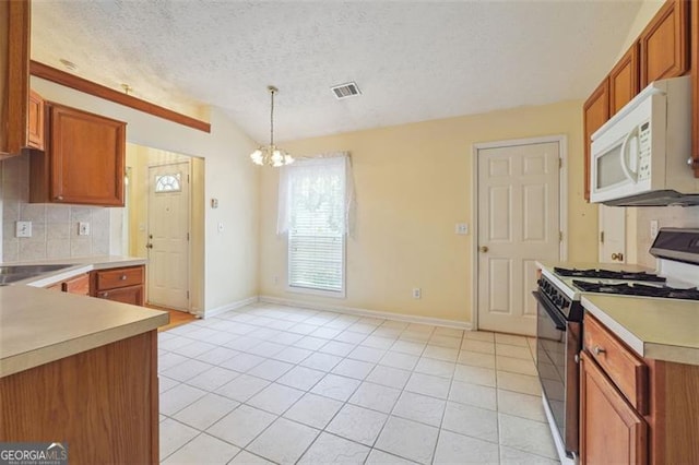 kitchen with vaulted ceiling, a textured ceiling, tasteful backsplash, stove, and decorative light fixtures