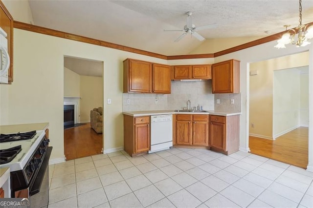 kitchen with a textured ceiling, sink, dishwasher, lofted ceiling, and gas range