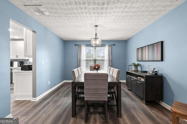 dining space featuring a textured ceiling and dark hardwood / wood-style flooring