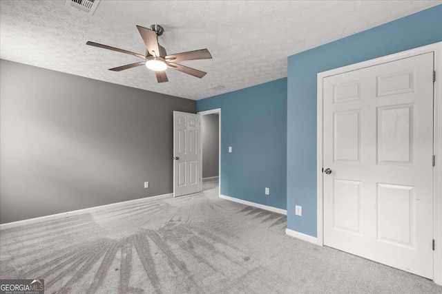 unfurnished bedroom with a textured ceiling, light carpet, and ceiling fan