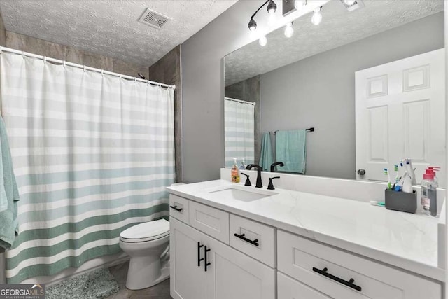 bathroom featuring vanity, a textured ceiling, and toilet