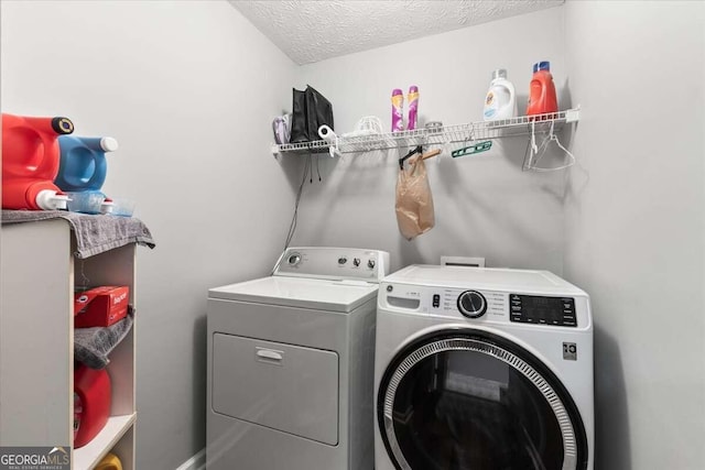 laundry room featuring washer and clothes dryer and a textured ceiling