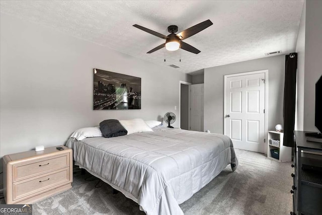 bedroom featuring a textured ceiling, ceiling fan, and carpet floors