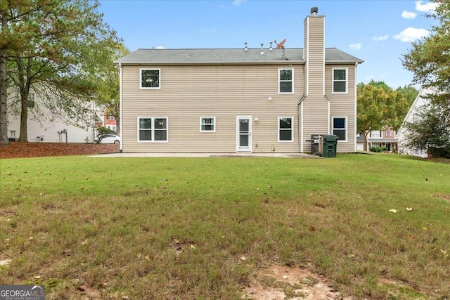 back of house with a patio area and a lawn