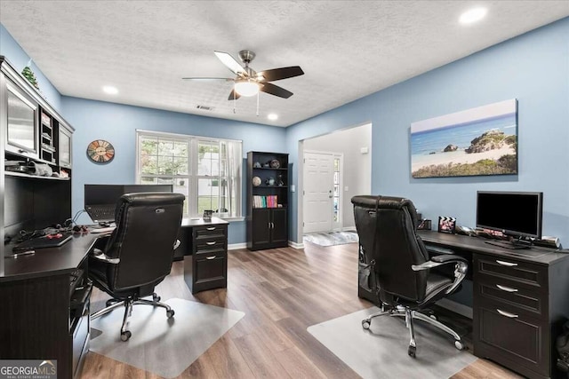 office space with ceiling fan, wood-type flooring, and a textured ceiling