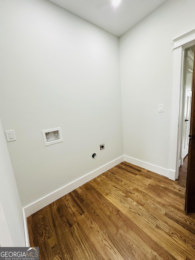 clothes washing area featuring baseboards, washer hookup, wood finished floors, and hookup for an electric dryer