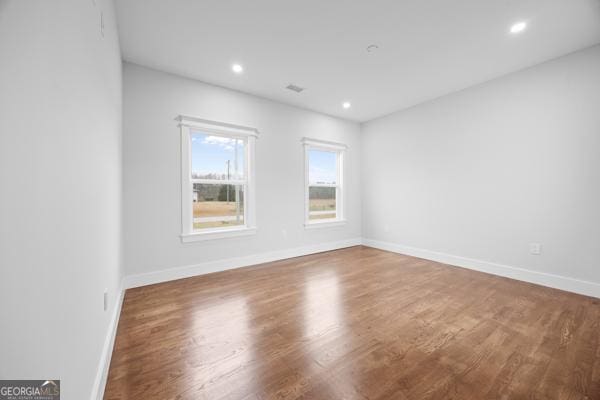 unfurnished room featuring recessed lighting, baseboards, and wood finished floors