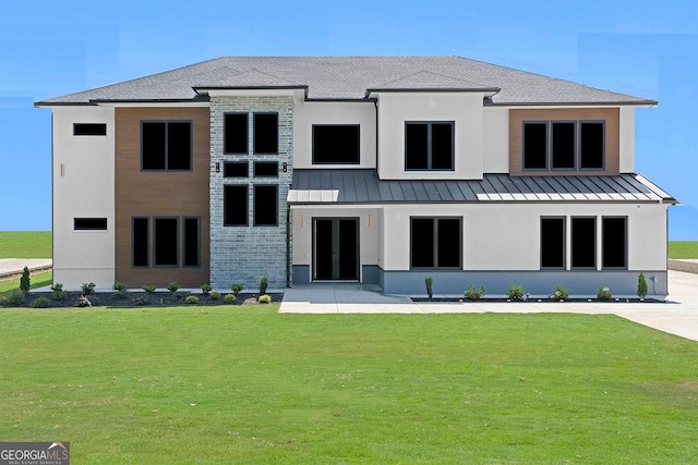 rear view of house featuring a yard