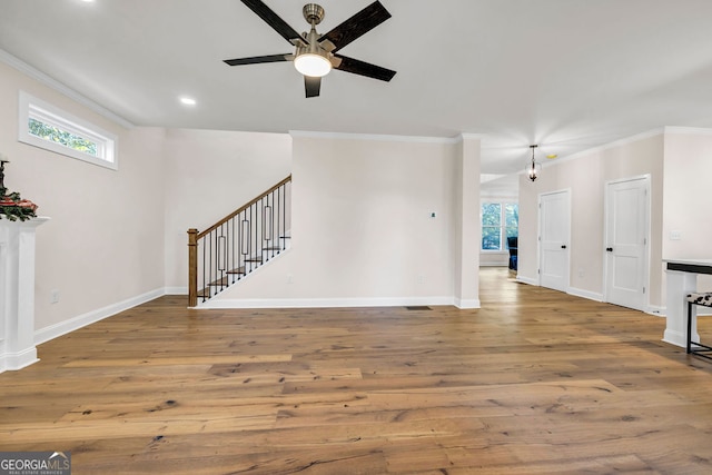 unfurnished living room with hardwood / wood-style flooring, ceiling fan, and ornamental molding