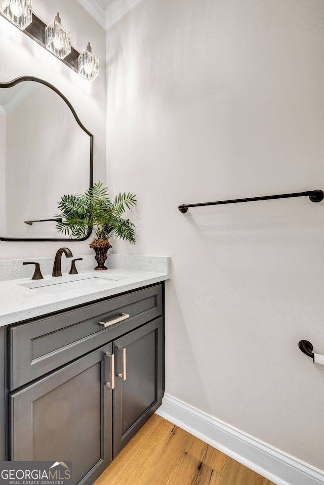 bathroom featuring hardwood / wood-style flooring, vanity, and crown molding