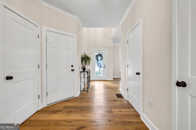 entryway with light hardwood / wood-style flooring and ornamental molding