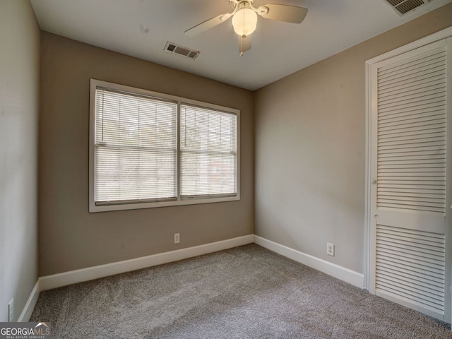 unfurnished room with ceiling fan and light carpet