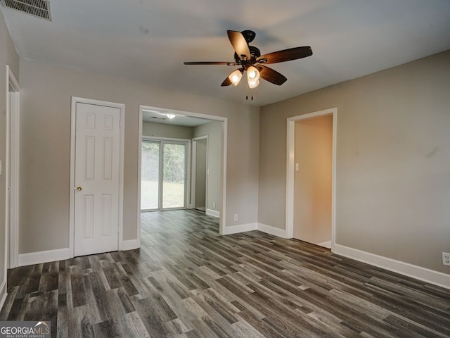 empty room with dark hardwood / wood-style flooring and ceiling fan