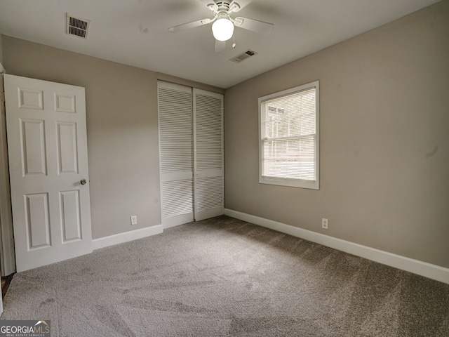 unfurnished bedroom with a closet, carpet, and ceiling fan