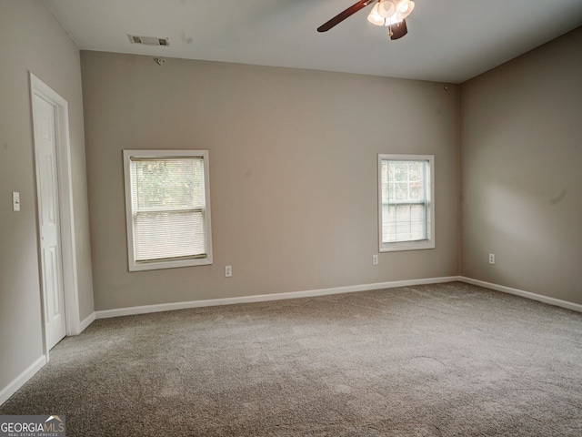 carpeted spare room featuring ceiling fan