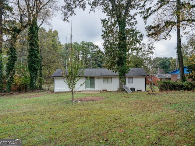 rear view of house featuring a lawn