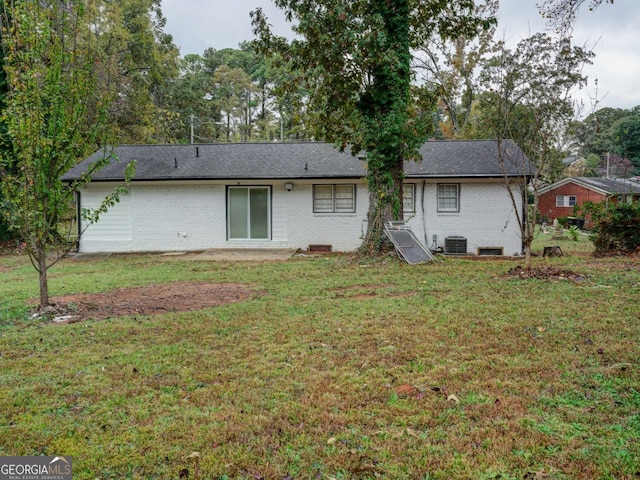 back of house with central AC and a lawn