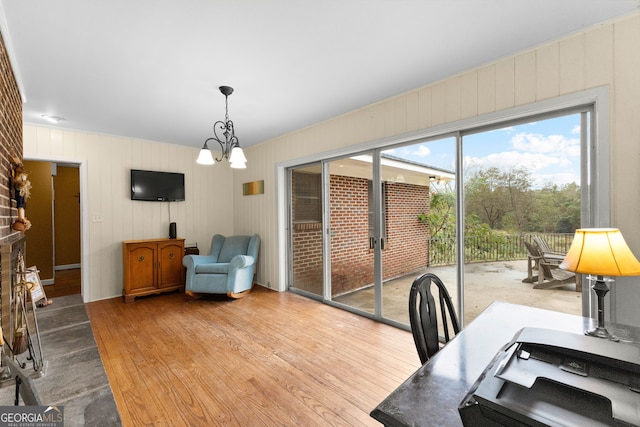 home office featuring light wood-type flooring and a chandelier