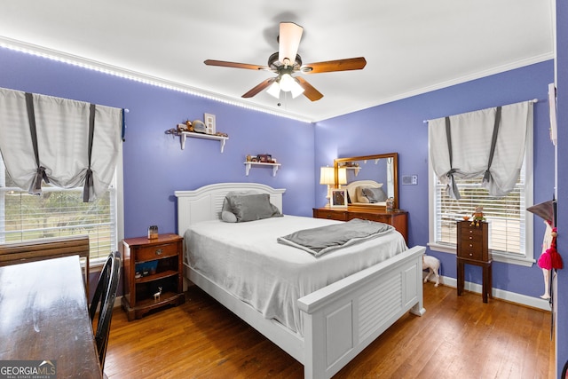 bedroom with ornamental molding, dark hardwood / wood-style flooring, multiple windows, and ceiling fan