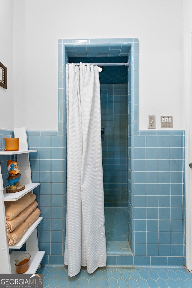 bathroom featuring walk in shower, tile patterned flooring, and tile walls