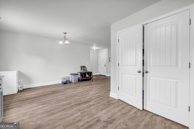 interior space with a notable chandelier and light hardwood / wood-style flooring