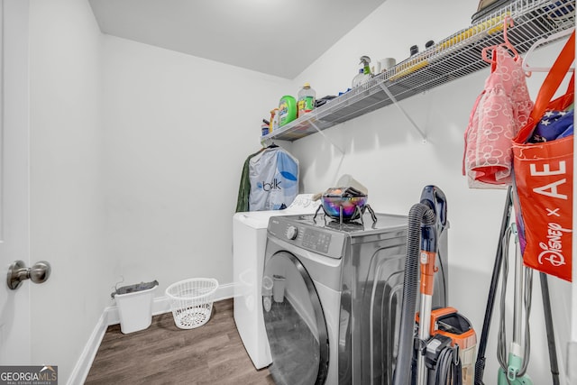 washroom with washer and clothes dryer and hardwood / wood-style flooring