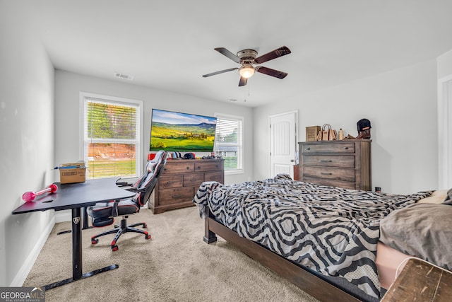 carpeted bedroom with ceiling fan and multiple windows