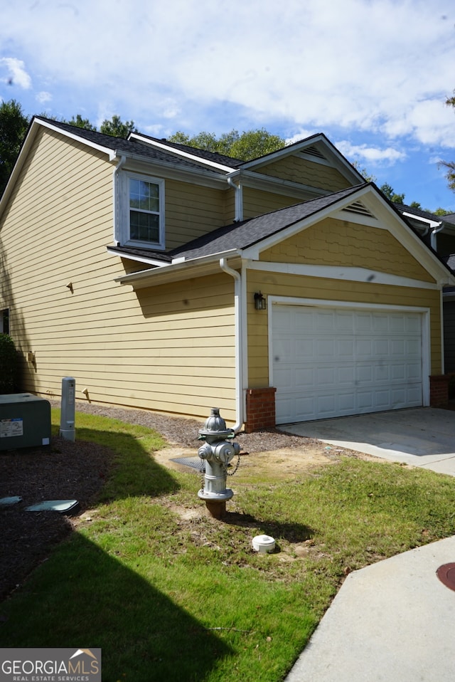 view of property exterior featuring a garage and a lawn