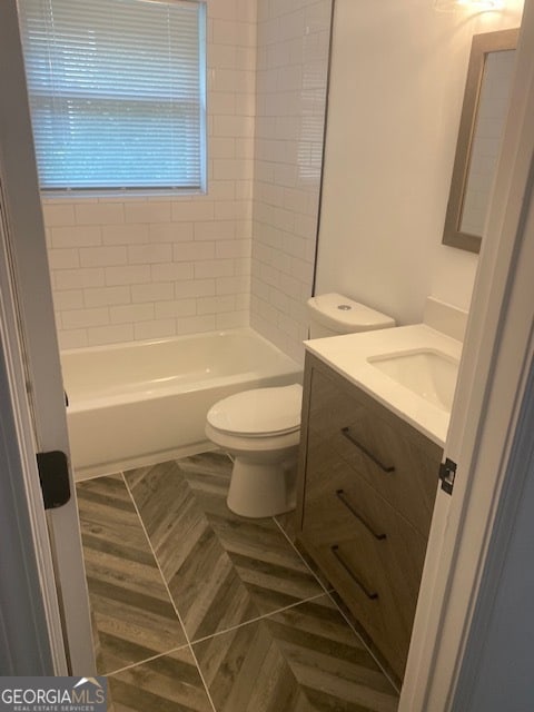 full bathroom featuring tile patterned floors, vanity, toilet, and tiled shower / bath combo