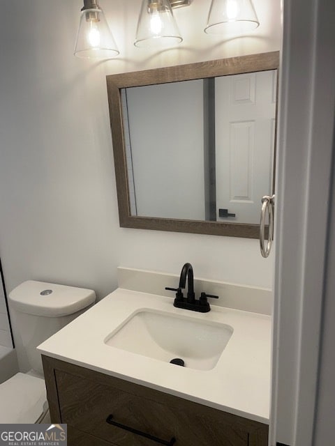 bathroom featuring a tub, vanity, and toilet