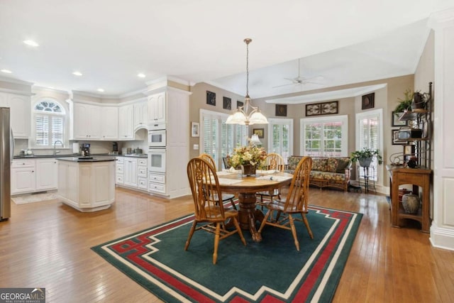 dining room featuring recessed lighting, vaulted ceiling, crown molding, ceiling fan with notable chandelier, and light wood-type flooring
