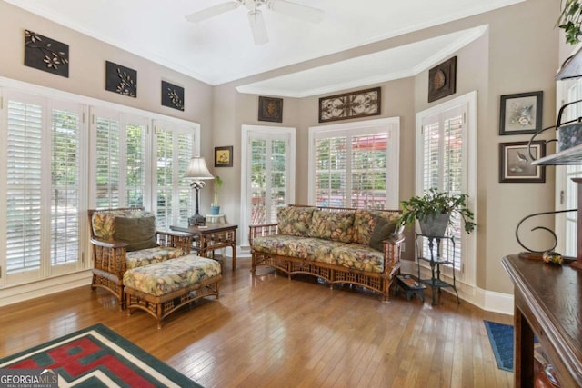 living room with wood-type flooring, plenty of natural light, and crown molding
