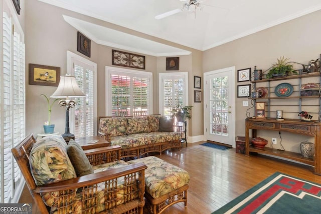 living room with crown molding, wood finished floors, a wealth of natural light, and ceiling fan