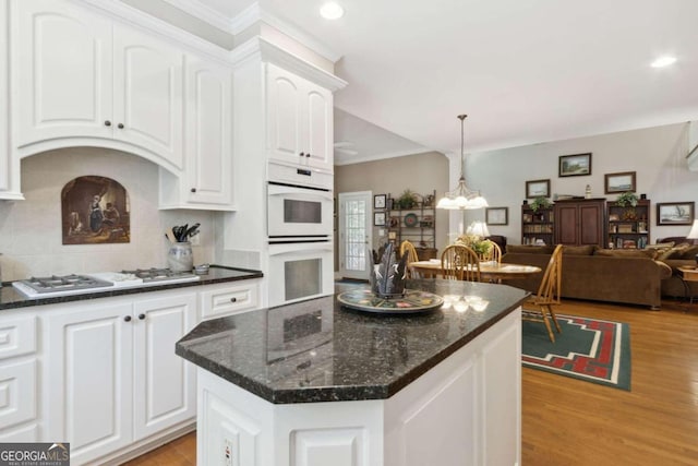 kitchen featuring open floor plan, white cabinetry, white appliances, light wood-style floors, and an inviting chandelier