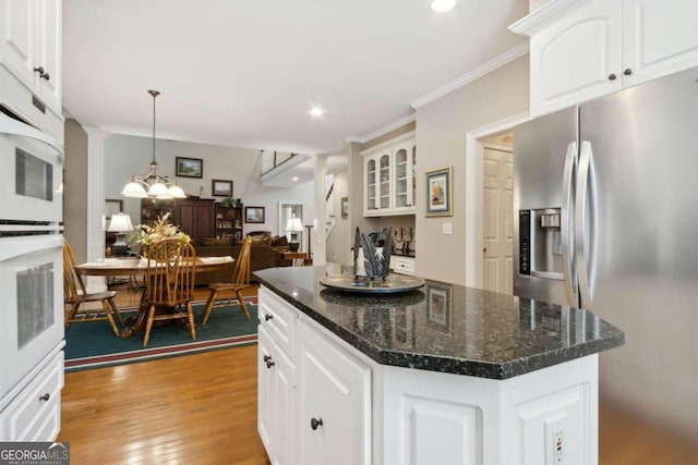 kitchen featuring a center island, crown molding, light wood-style floors, stainless steel refrigerator with ice dispenser, and white cabinetry