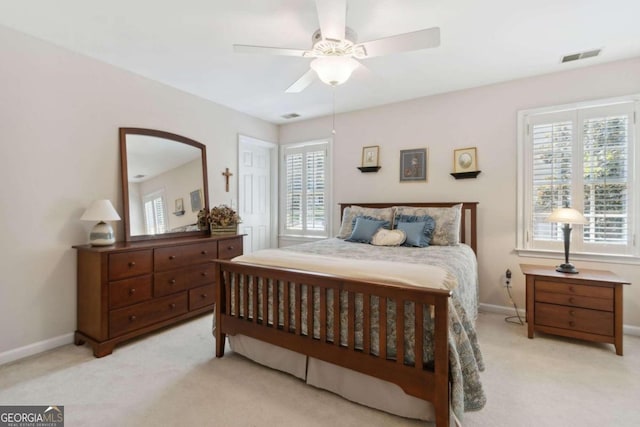 bedroom featuring light carpet, visible vents, a ceiling fan, and baseboards
