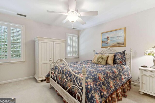 carpeted bedroom featuring visible vents, a ceiling fan, and baseboards