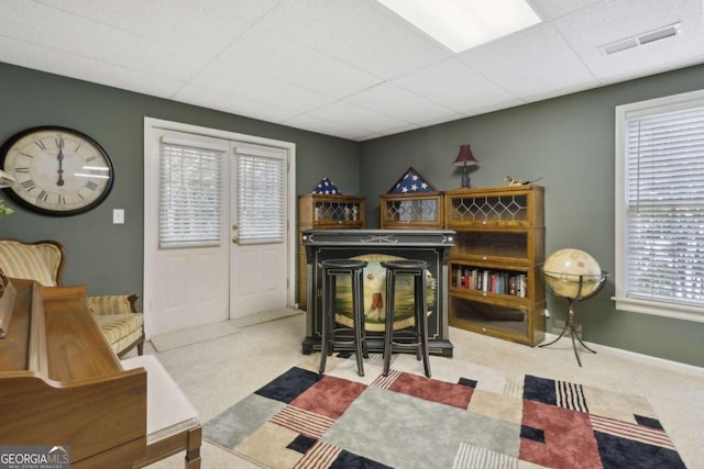 bar featuring visible vents, baseboards, a paneled ceiling, and carpet