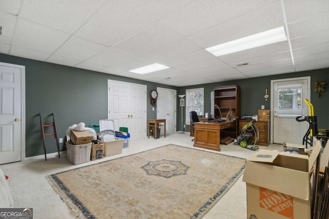 carpeted office with a paneled ceiling and baseboards